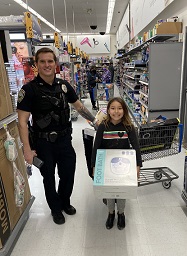 Shop with a Cop School Resource Officer Foley with child in store