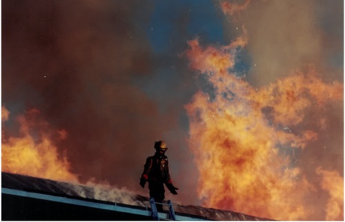 Firefighter standing on burning building