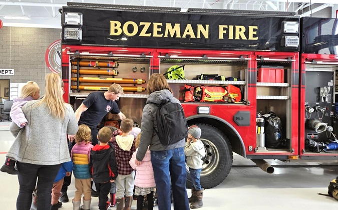 Firefighter giving tour of engine to preschool students