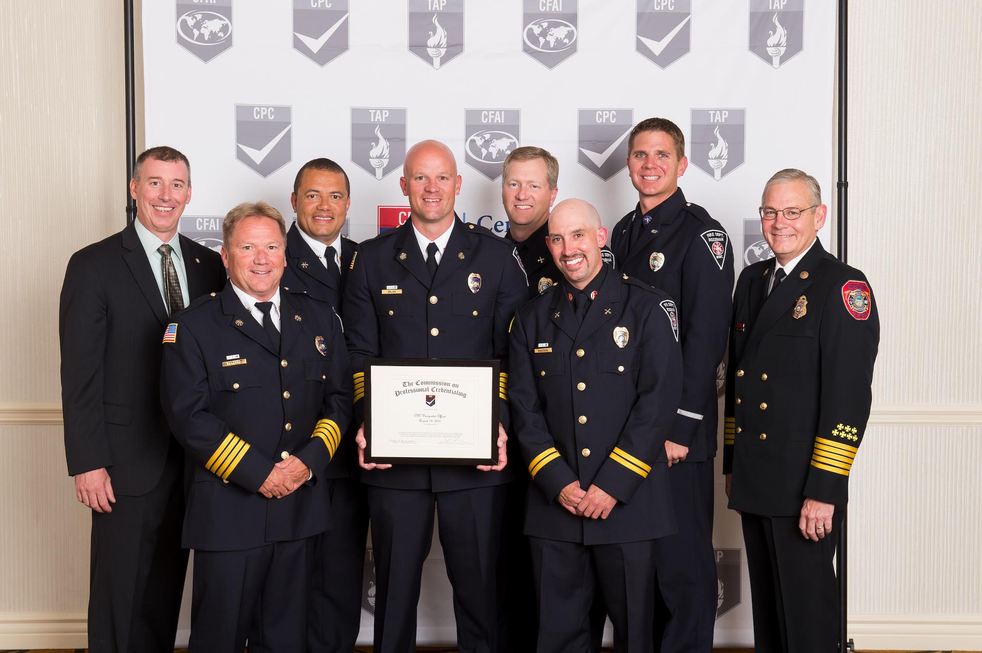 Eight firefighters wearing class A's recieving awards