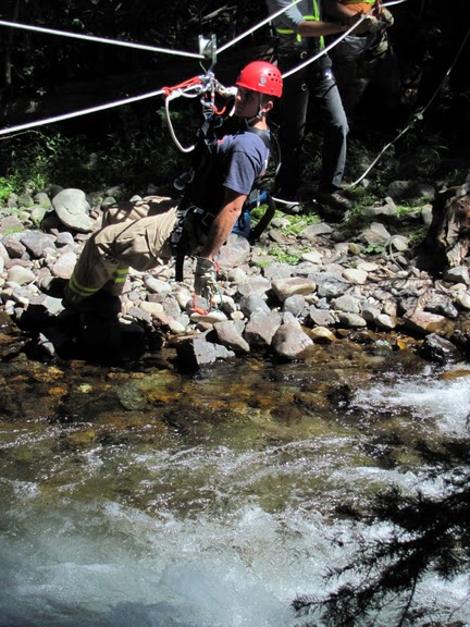 firefighter on rope over a river