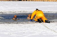 Firefighter resuce dogs in semi frozen body of water